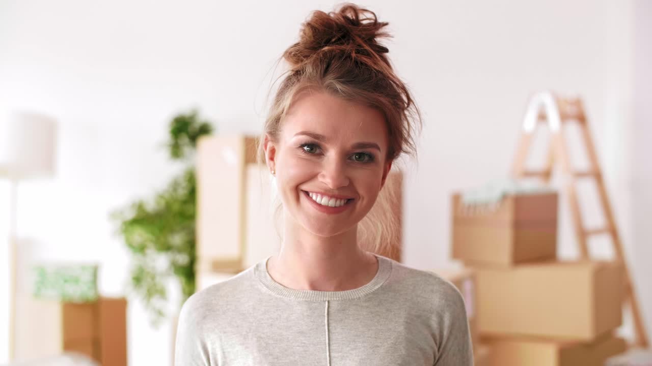 retrato de una mujer joven sonriente en su nuevo apartamento