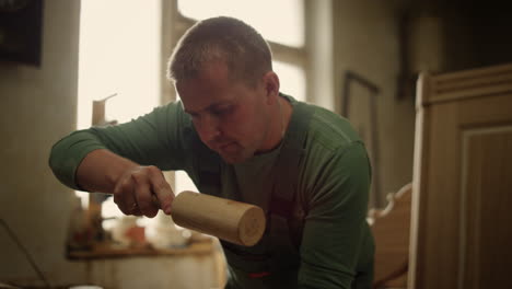 Serious-man-decorating-wooden-product-indoors.-Wood-worker-using-tools-in-studio