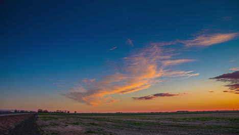 beautiful-blue-and-yellow-sky-at-sunset-on-countryside-meadow-beside-a-highway