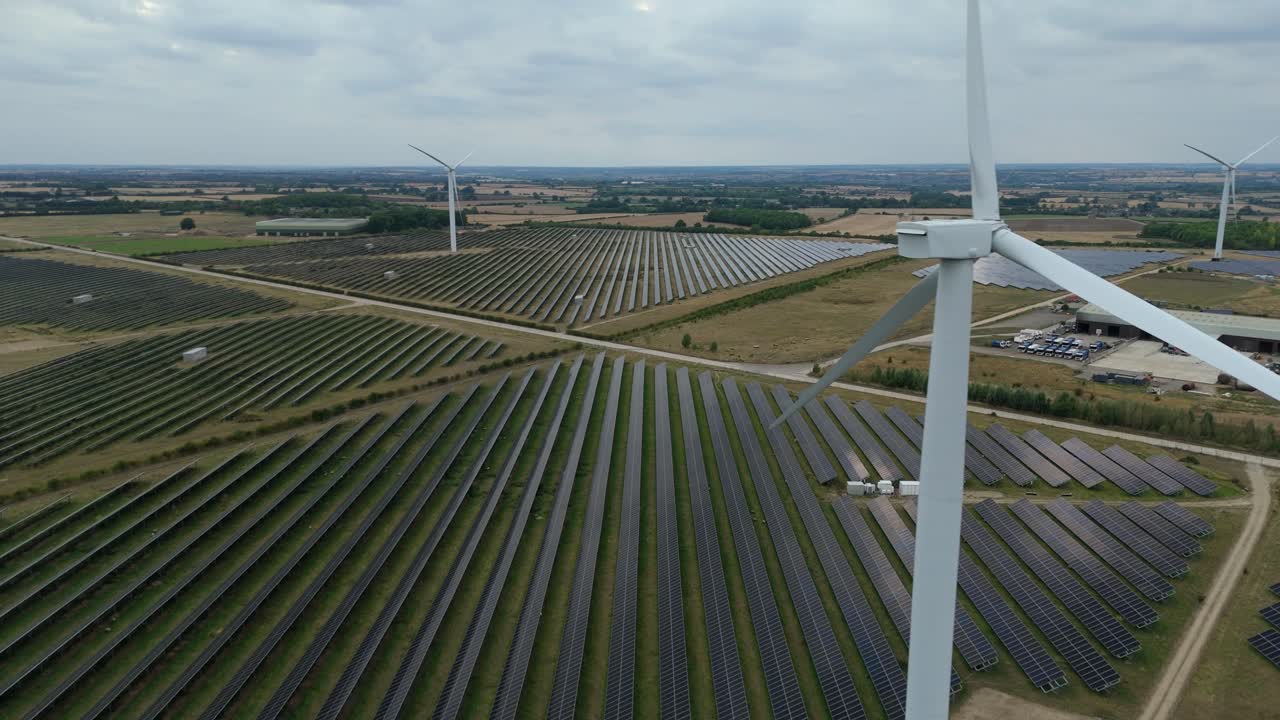 Drone view of sustainable power plant with solar panels and rotating turbines in Raunds England UK