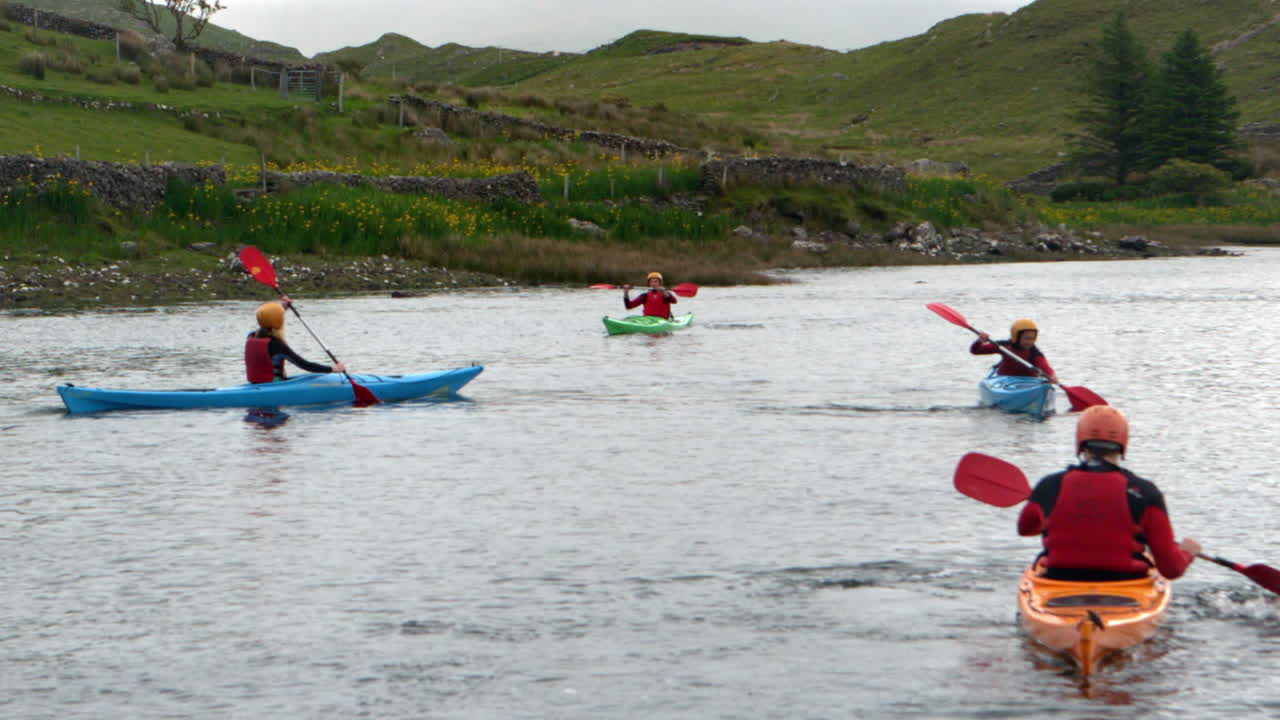 Amici che fanno kayak insieme in un lago in campagna