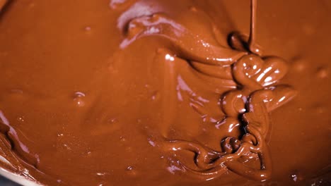 spoon stirring rich, melted chocolate in bowl