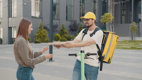 woman receiving pizza delivery from delivery person