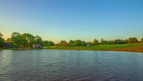 timelapse of a cottage on the side of a pond