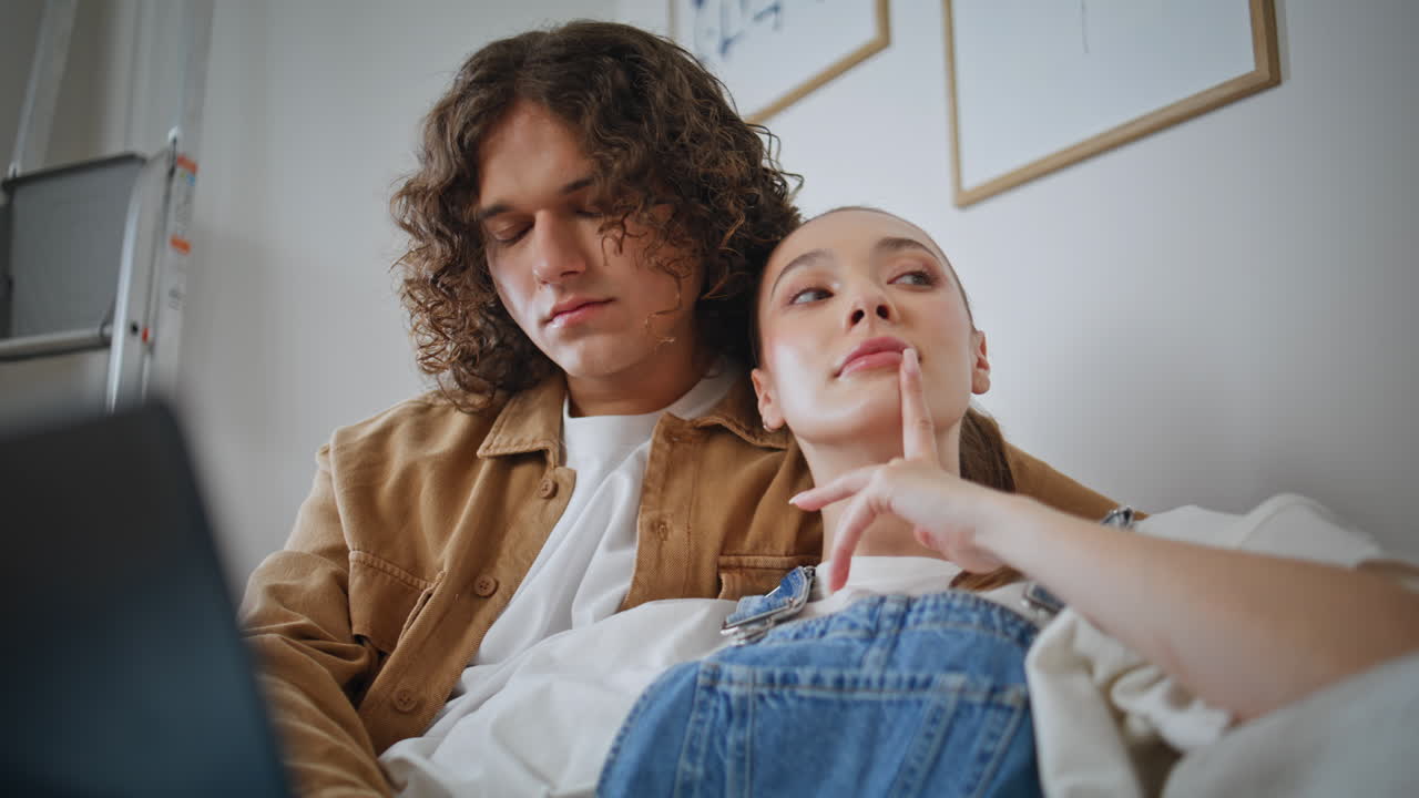 Relaxed pair sitting living room couch looking laptop closeup. Romantic couple