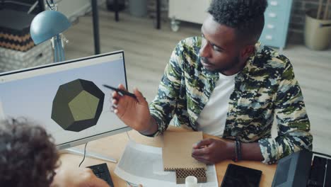 young specialists working in office using computer and 3d printer talking