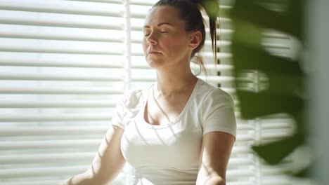 Tilt-up-video-of-pregnant-woman-meditating-in-the-sun.