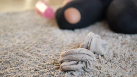 woman sitting on a gray carpet with socks on the floor