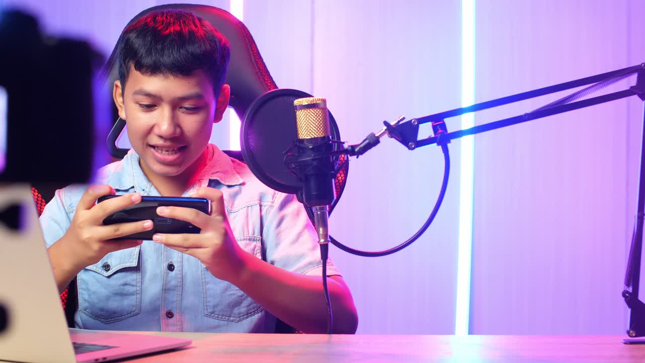 Excited Asian Kid Boy Playing Video Game With Mobile Phone While Live Stream