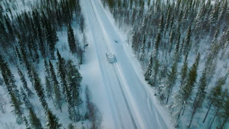 drone sigue a camper viajando por carretera de invierno en laponia, finlandia