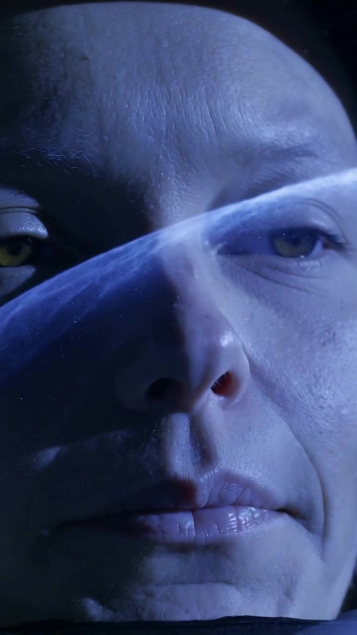 Video verticale: Fascia che si muove che fa sbattere le palpebre a una donna matura, aprendo gli occhi sotto una luce blu in studio