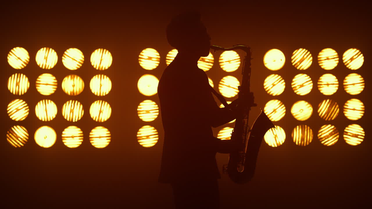 무대에서 연주하는 알려지지 않은 재즈 남자 색소폰 연주자. 현대 색소폰을 들고 있는 연주자.