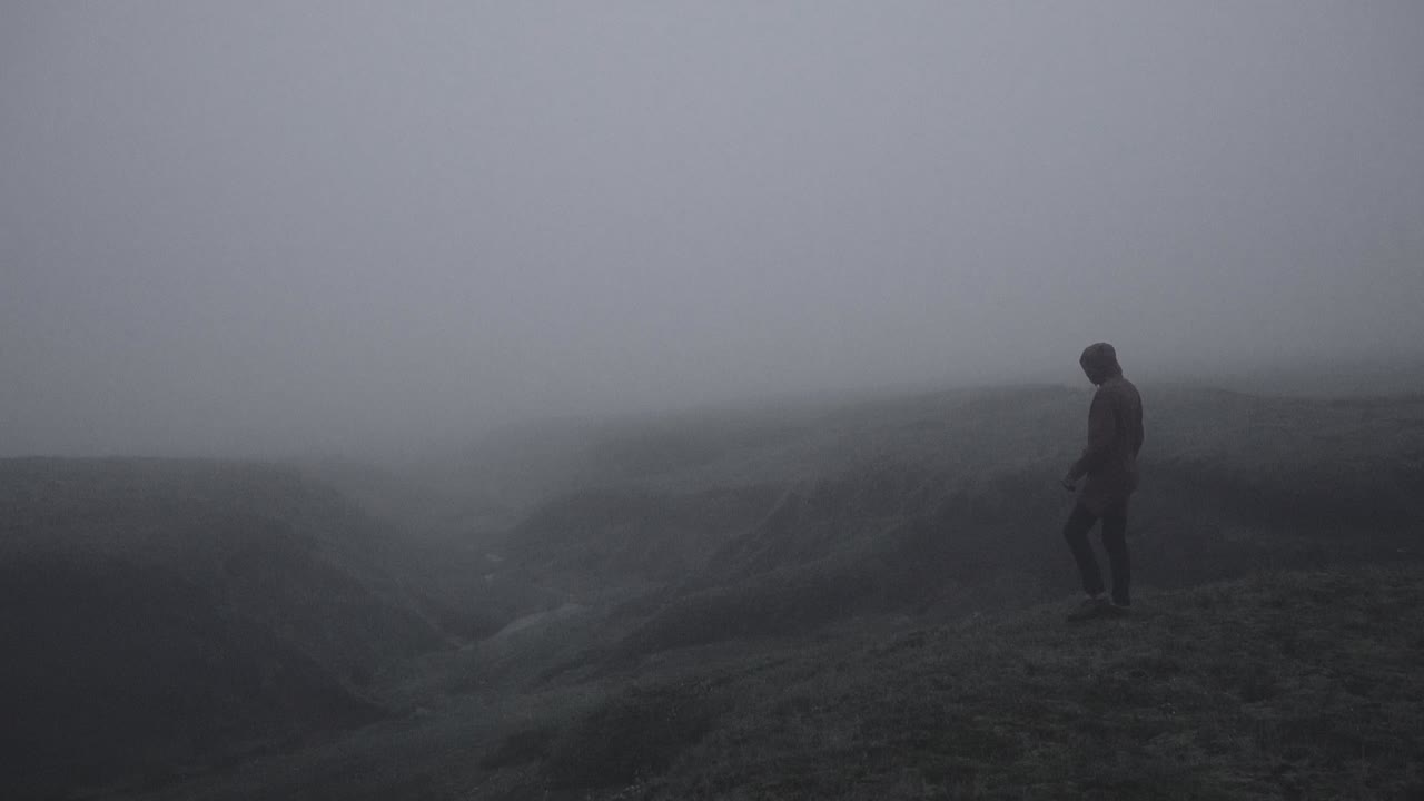 silueta en un cañón islandés abandonado en un paisaje brumoso, cambiante y dramático