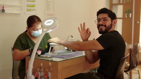 latin-mexican-Satisfied-clients-with-manicure-service-client-patient-at-manicure-wellness-center-spa-bar-beard-handsome-smile-happy