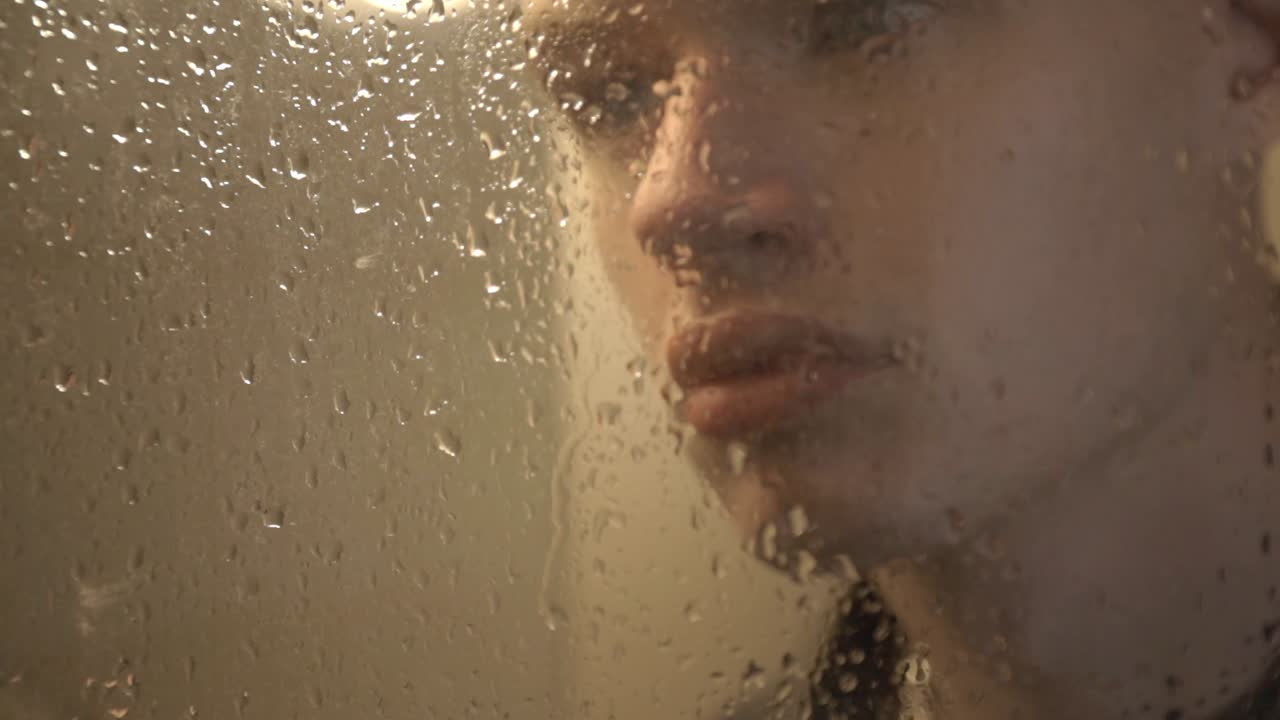 Young Man Standing And Looking Behind The Window Glass With Raindrops. - close up shot
