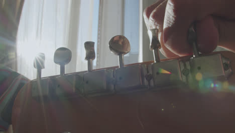 close-up of a person tuning an electric guitar in sunlight
