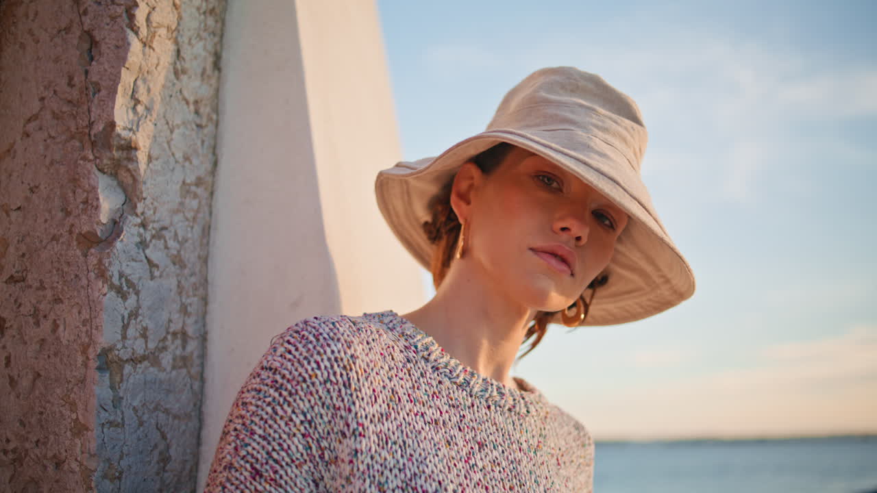 조용한 관광객이 저녁에 바가에서 포즈를 취하고 있습니다. 모자를 입은 평화로운 아름다운 소녀입니다.