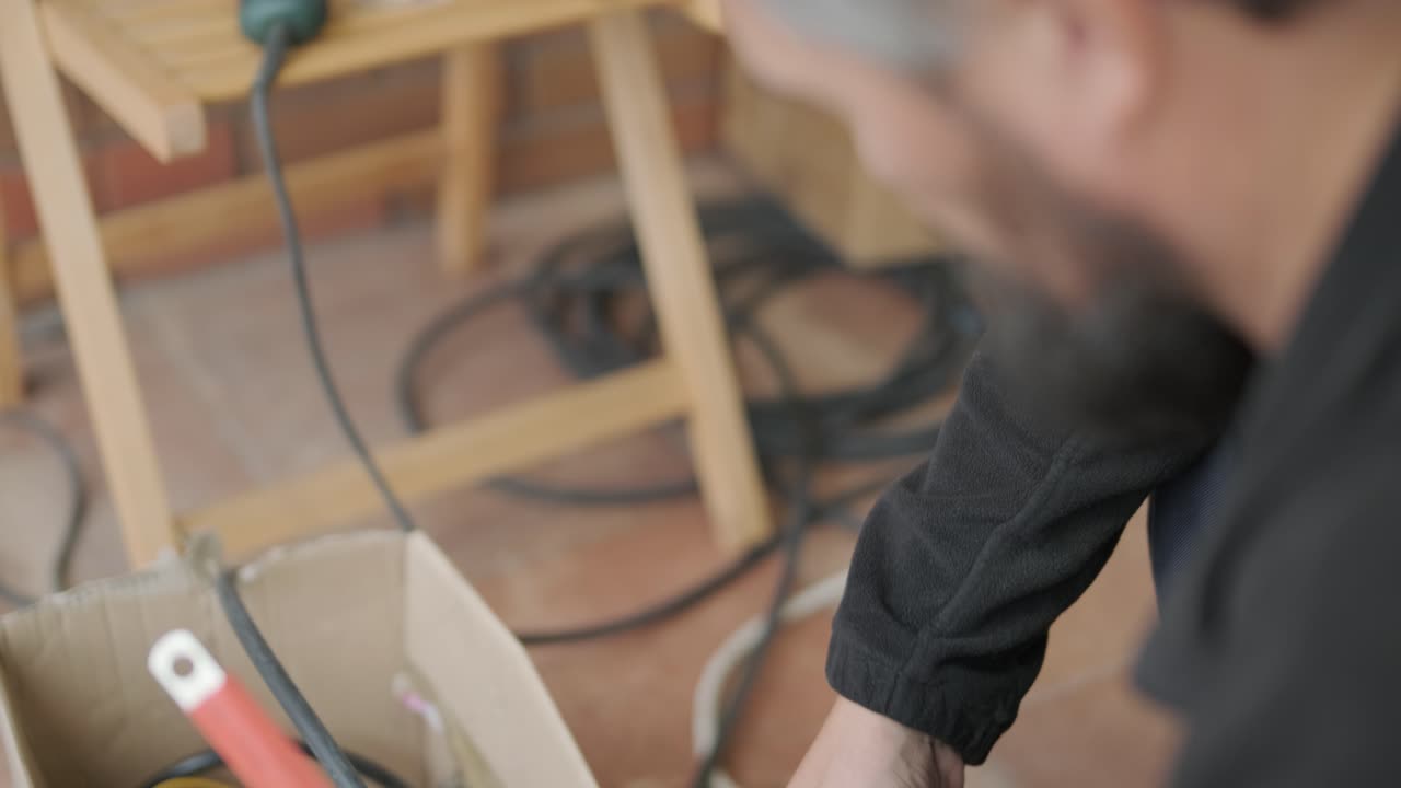 An electrician installing an inverter in a home. The image shows technical skill, modern tools, and attention to safety in electrical work