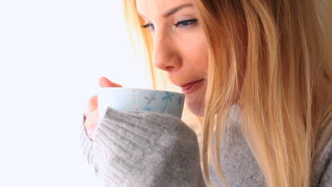 rubia atractiva con ropa de invierno sosteniendo una taza de café