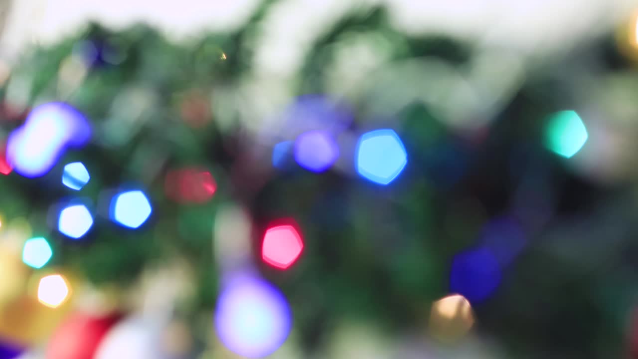 las luces de colores de navidad parpadean brillantemente fuera de foco.