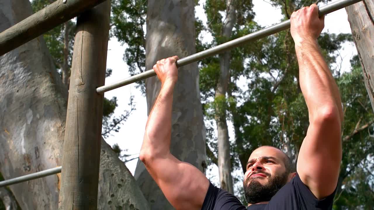 hombre realizando pull-ups en el campamento de entrenamiento