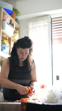 woman chopping carrots in a kitchen