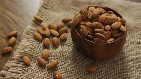 Vídeo-De-Almendras-En-Un-Recipiente-Sobre-Fondo-De-Madera