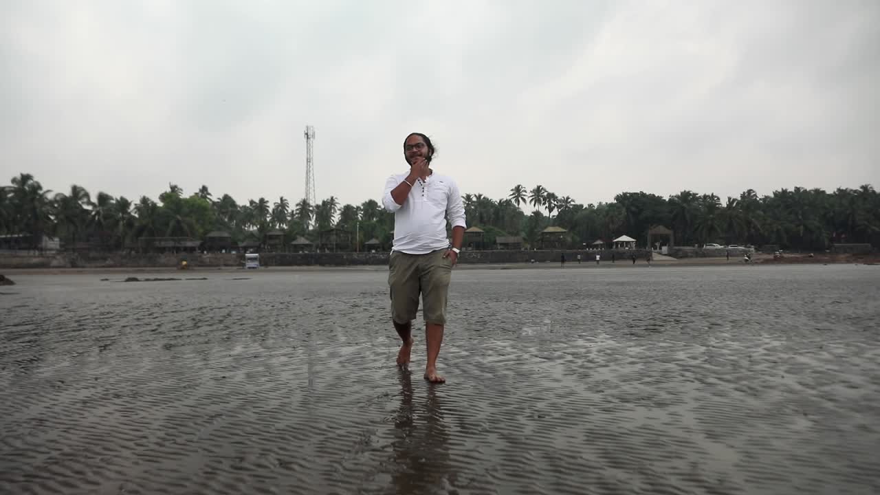 해변에서 걷고 있는 인도의 긴 머리 소년 gorai india vivekanand ingle 팔로우 샷 긴