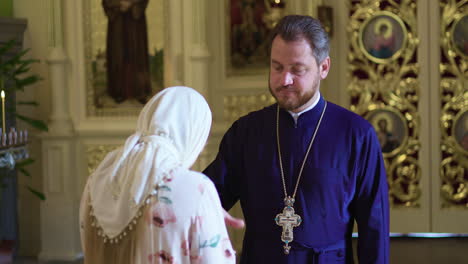 mujer acercándose al sacerdote