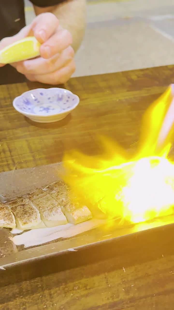 el chef usa un soplador para hornear el plato de pescado.