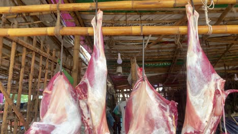 hanging raw goat meat at butchers market in bangladesh