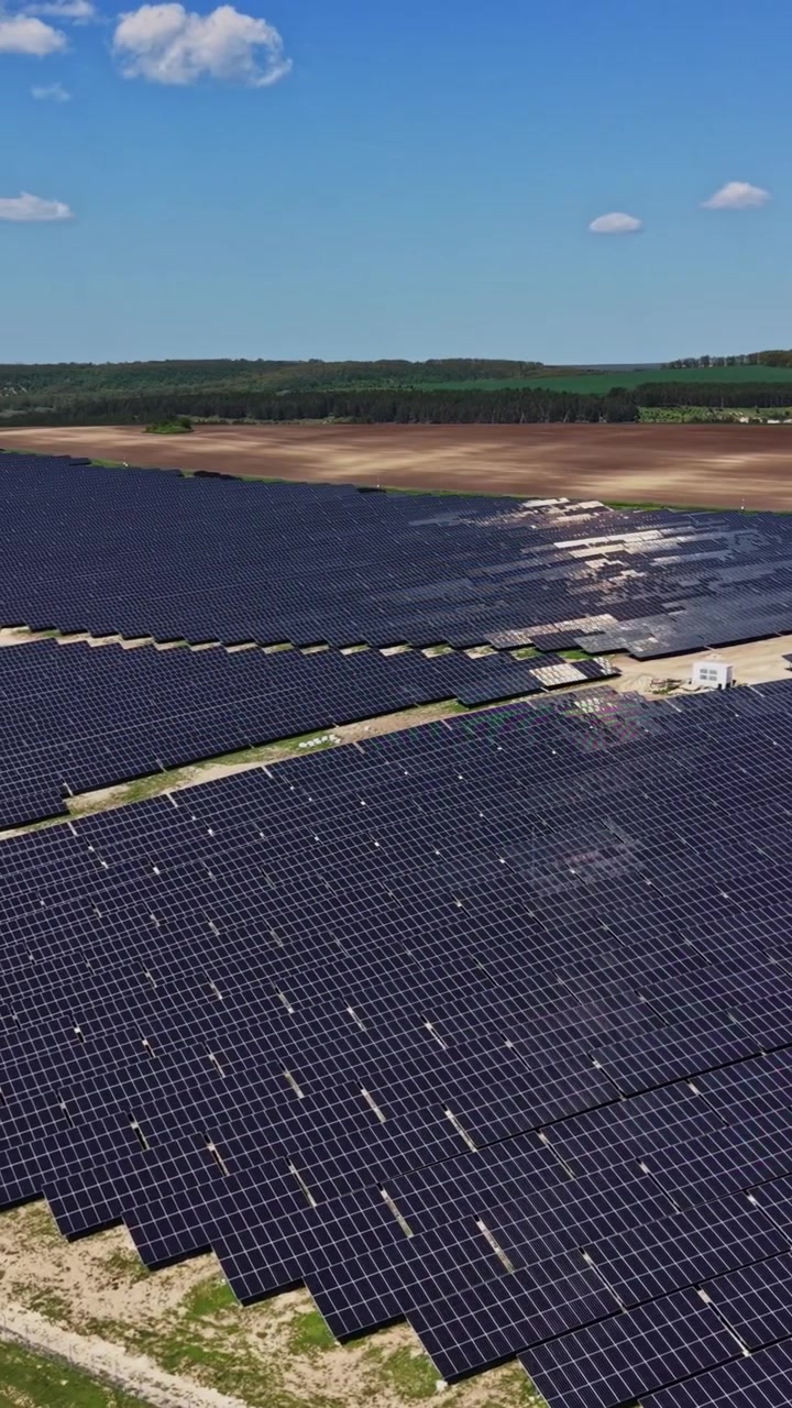 Solpaneler dækker et stort landområde i et solrigt landskab.