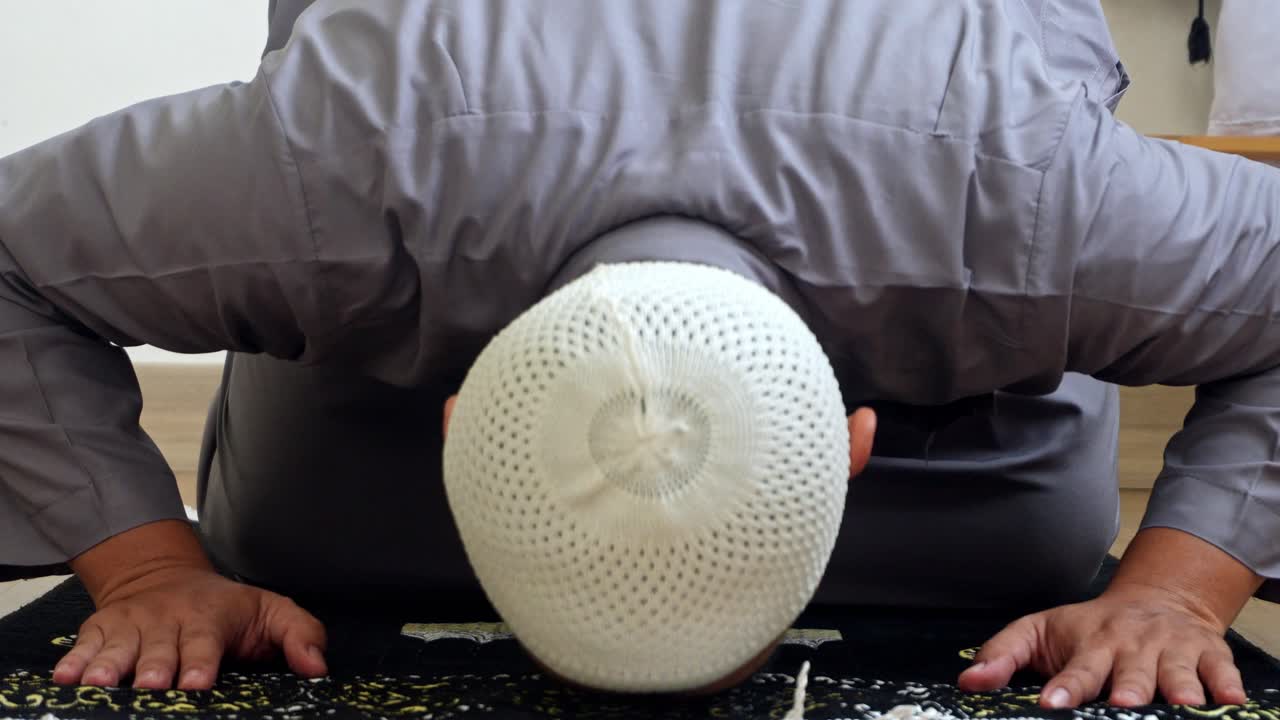Close Up Of Muslim Man Performing Sujud And Final Movement Of Salah, The Tashahhud While Sitting On Prayer Mat