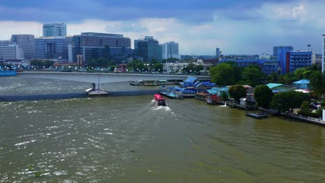 puente rama viii con barcos tradicionales que navegan a través del río chao phraya en la ciudad de bangkok, tailandia