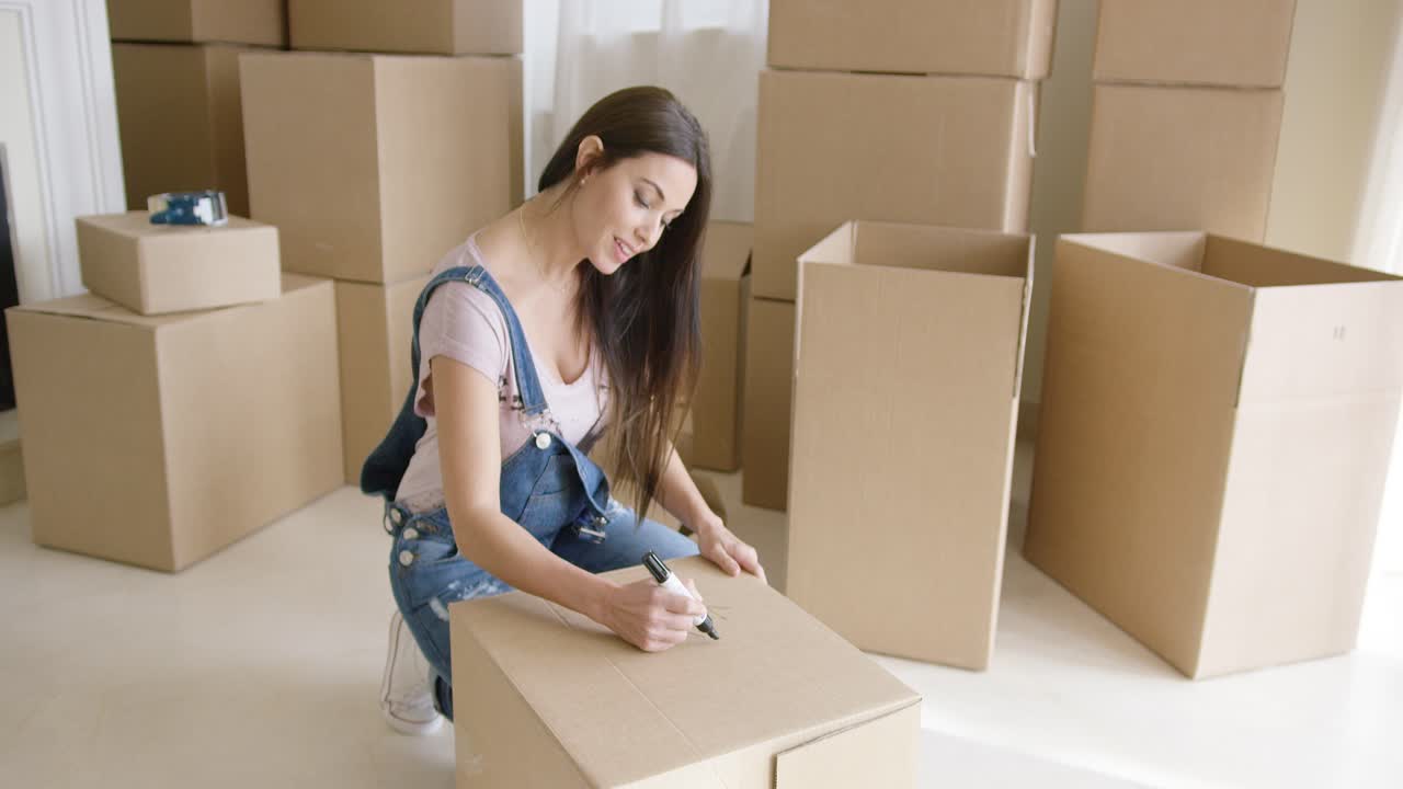 una mujer bonita empacando sus pertenencias personales.