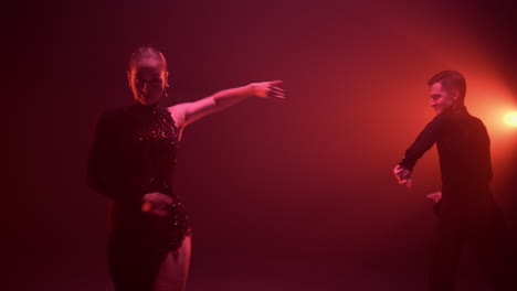 ballroom couple performing with latin program. couple dancing in dark hall.