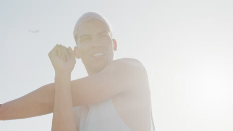 happy biracial man stretching on promenade, in slow motion