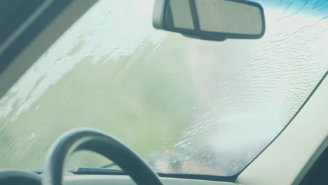 inside view of a car a woman washes her car with a high pressure washer