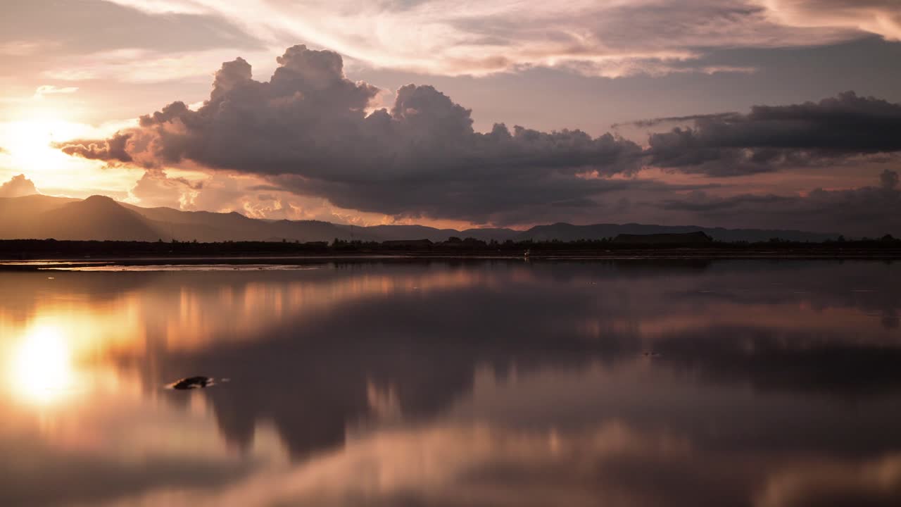 Mirror image cloud reflections at sunset on the salt fields of the south east Asia Monsoon season