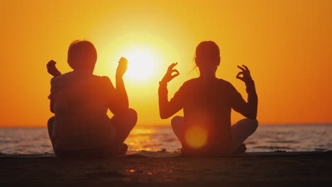 Großmutter-Und-Enkelin-Meditieren-Am-Strand-Aktives-Und-Gesundes-Seniorenkonzept