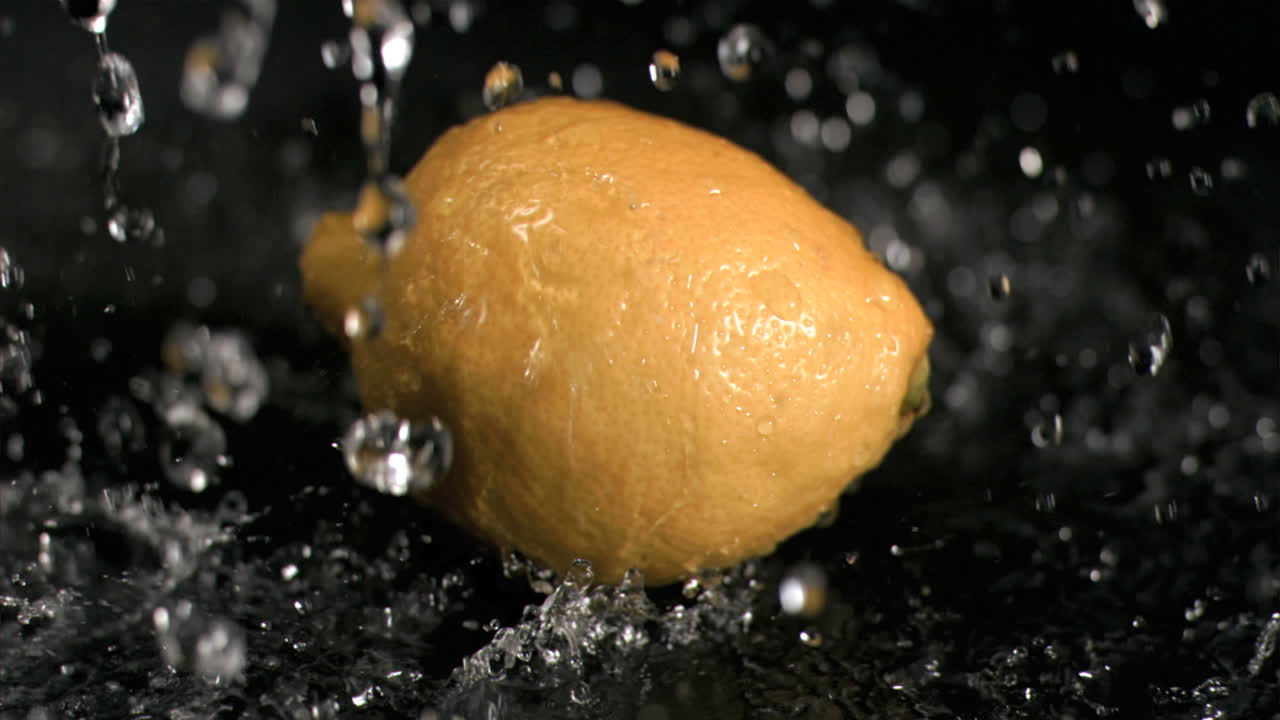 Water raining on lemon in super slow motion