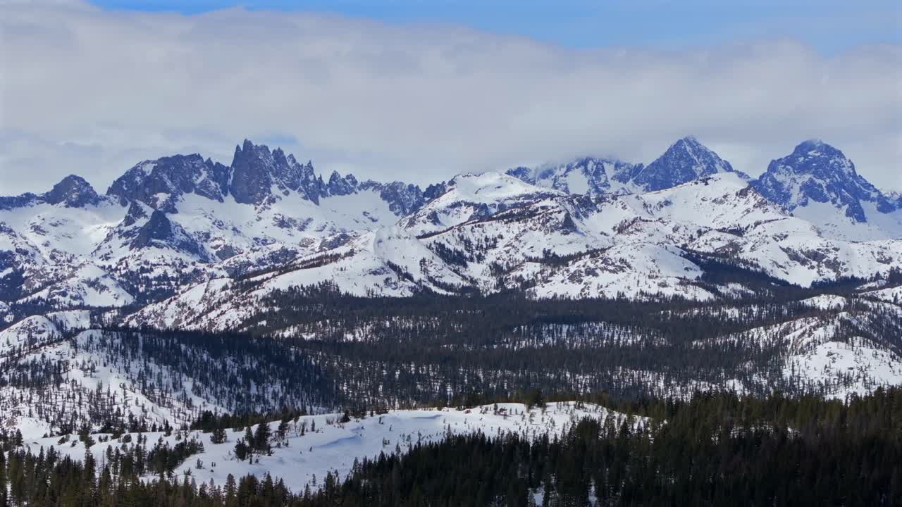Minarets-Gebirgskette mit zerklüfteten, aufragenden Gipfeln, Panoramalandschaft vom Aussichtspunkt, Wechte, Skigebiet Mammoth Mountain, Drohnenaufnahme Kalifornien, Winter und Frühling, sonniger blauer Himmel am Morgen, Inyo Nationalforst, vorwärts.