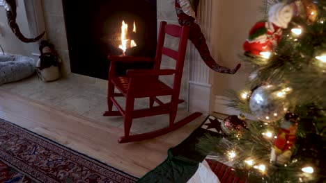 child's rocking chair by a fireplace and christmas tree decorated with ornaments and lights