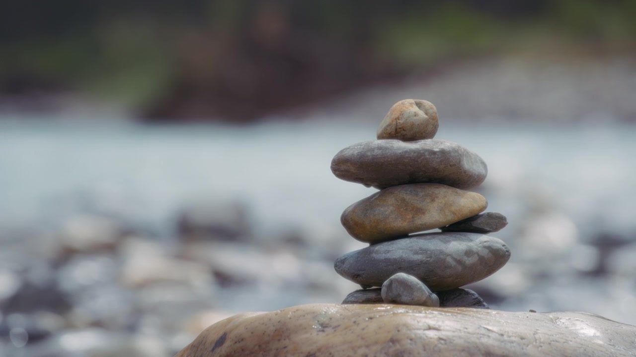Close up of balanced stones stacked near the river shore