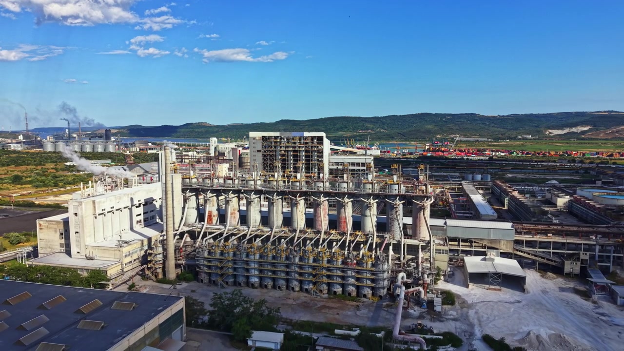 Gran instalación industrial ubicada cerca de un río con maquinaria y unidades de almacenamiento visibles durante el día.
