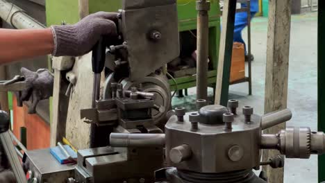 fotografía de cerca de la mano del operador usando guantes para controlar la máquina de fresado cnc