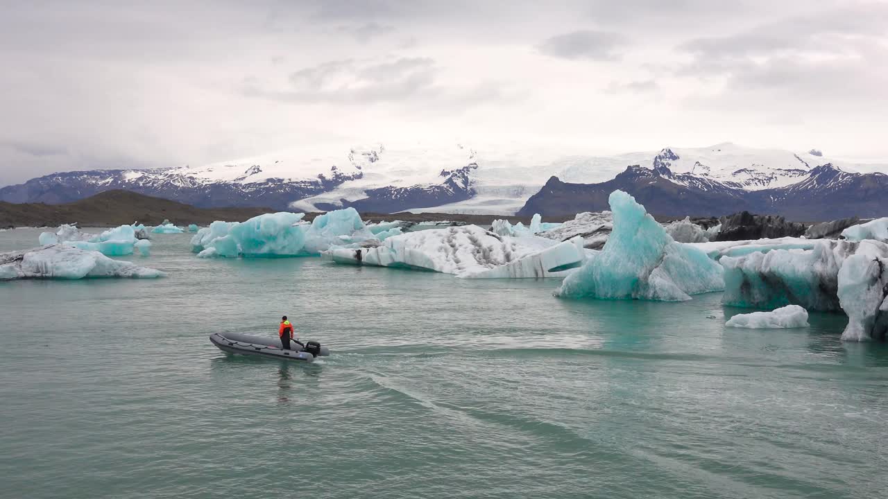 jokulsarlon iceland의 녹는 빙하 석호에서 조디악 보트가 빙산을 통과합니다.