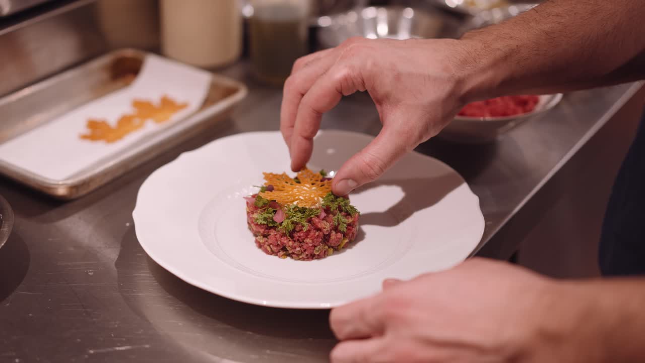 cocinero masculino puso decoración en el plato blanco con aperitivo