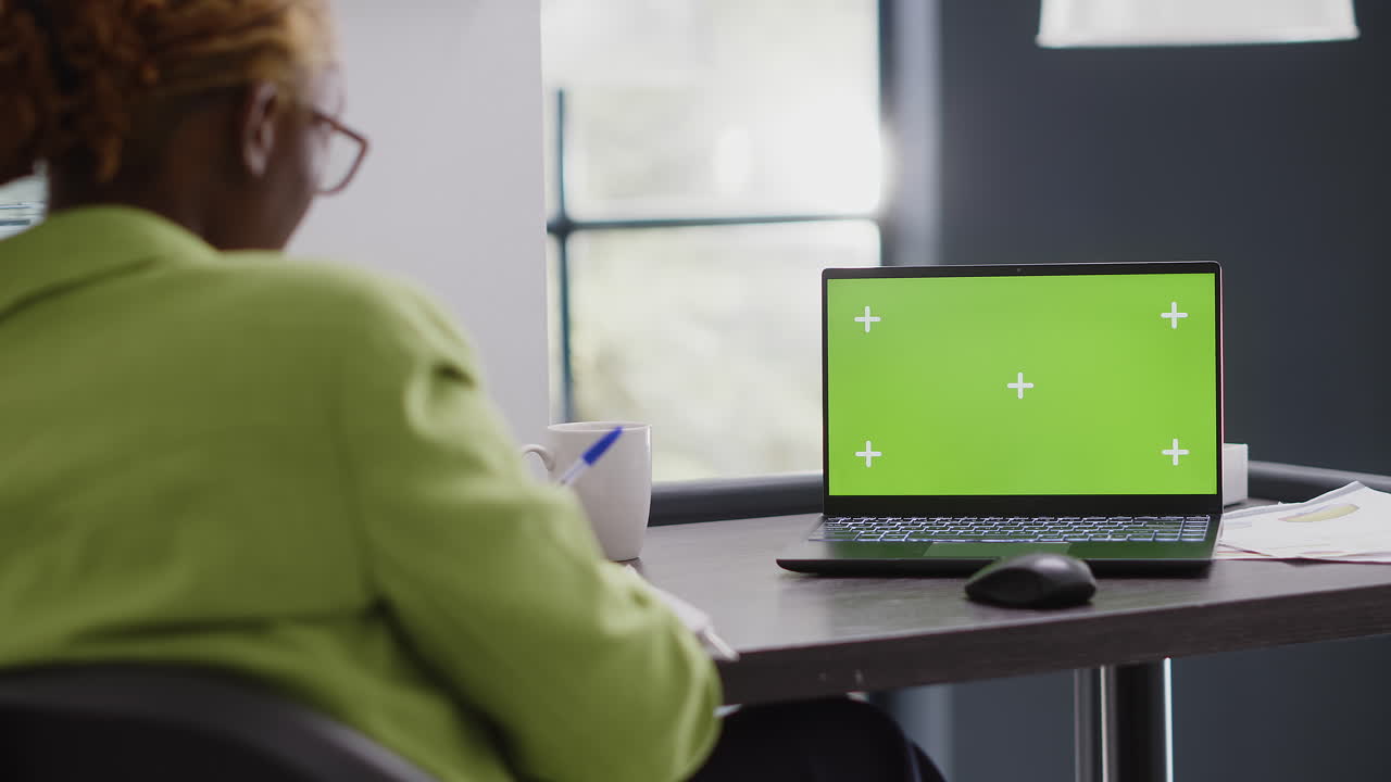 mujer trabajando en una computadora portátil con pantalla verde