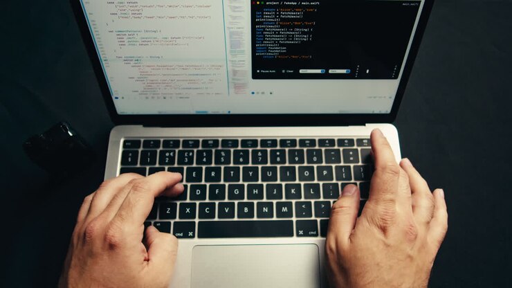 Close-Up of Hands Typing Code on Laptop Keyboard